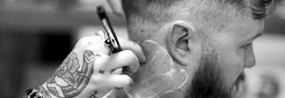 Closeup of barber shaving a clients neck with straight razor